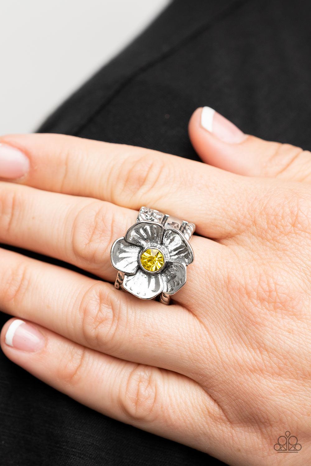 Paparazzi Accessories Prismatically Petunia - Yellow Textured silver petals gently gather around a sparkling yellow rhinestone center, blooming into a dazzling floral centerpiece atop the finger. Features a stretchy band for a flexible fit. Sold as one in