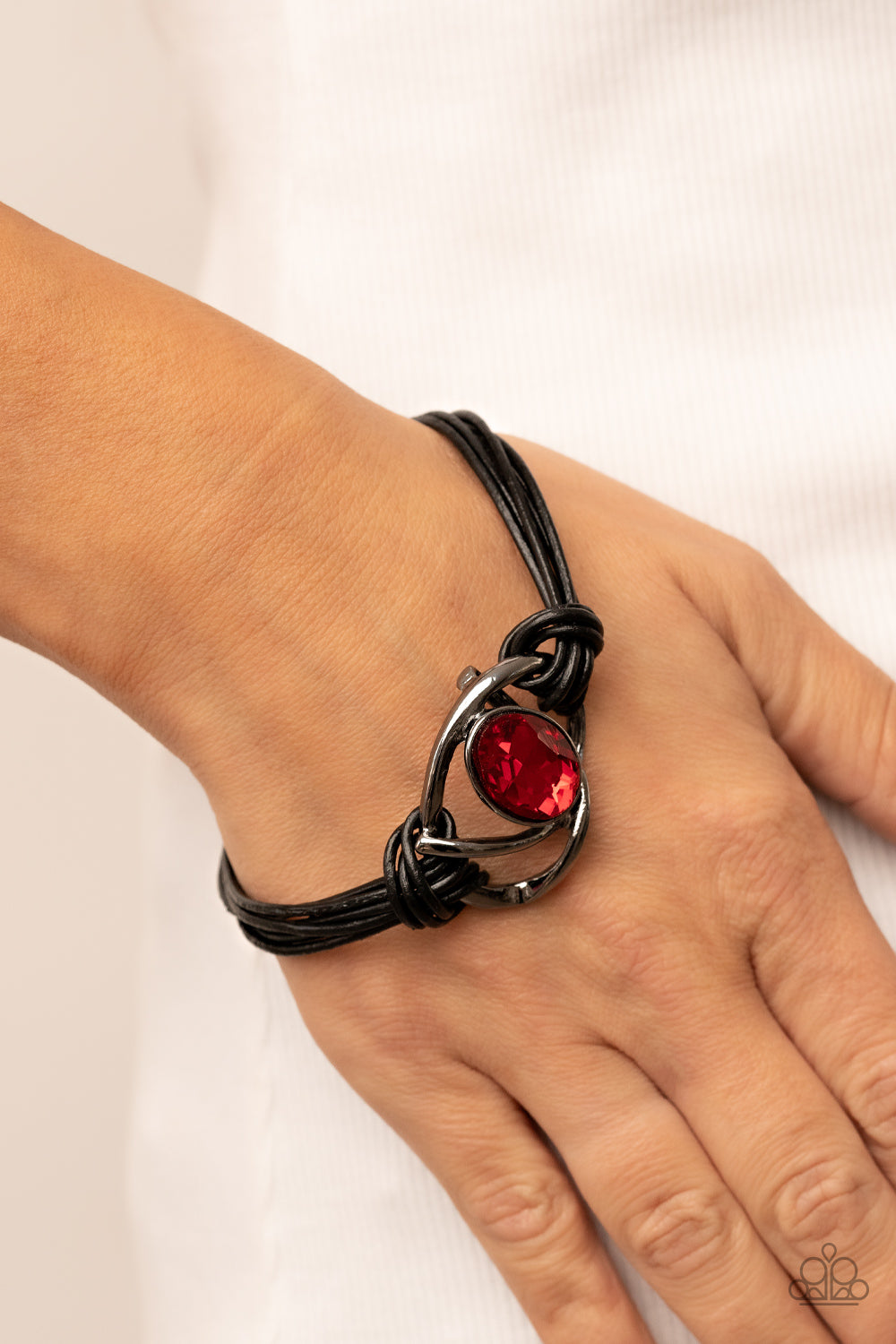 Paparazzi Accessories Keep Your Distance - Red Shiny gunmetal bars abstractly twist around an oversized oval red gem, resulting in a mesmerizing centerpiece that is knotted in place with layers of black leather cording. Features a magnetic closure. Sold a