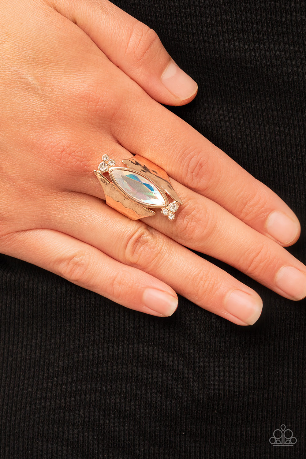 Paparazzi Accessories Planetary Paradise - Rose Gold An oversized marquise cut iridescent gem asymmetrically balances between two flared and hammered rose gold frames. Clusters of dainty white rhinestones flanks the spellbinding centerpiece for a delicate
