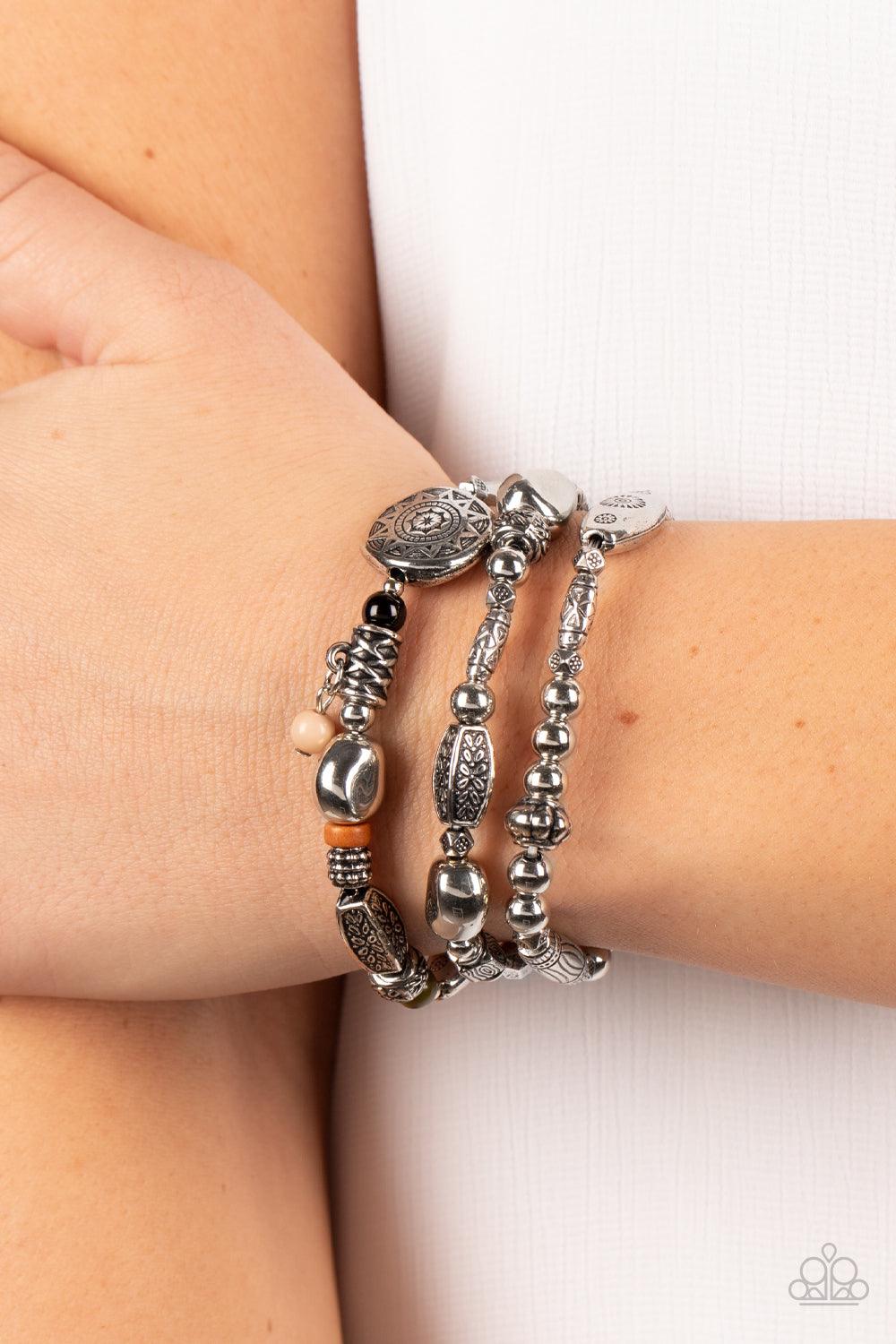 Paparazzi Accessories Western Quest - Multi Infused with hints of black, Olive Branch, Adobe, and Soybean accents, a mismatched collection of silver beads, textured silver accents, and floral and sunburst embossed beads are threaded along stretchy bands a