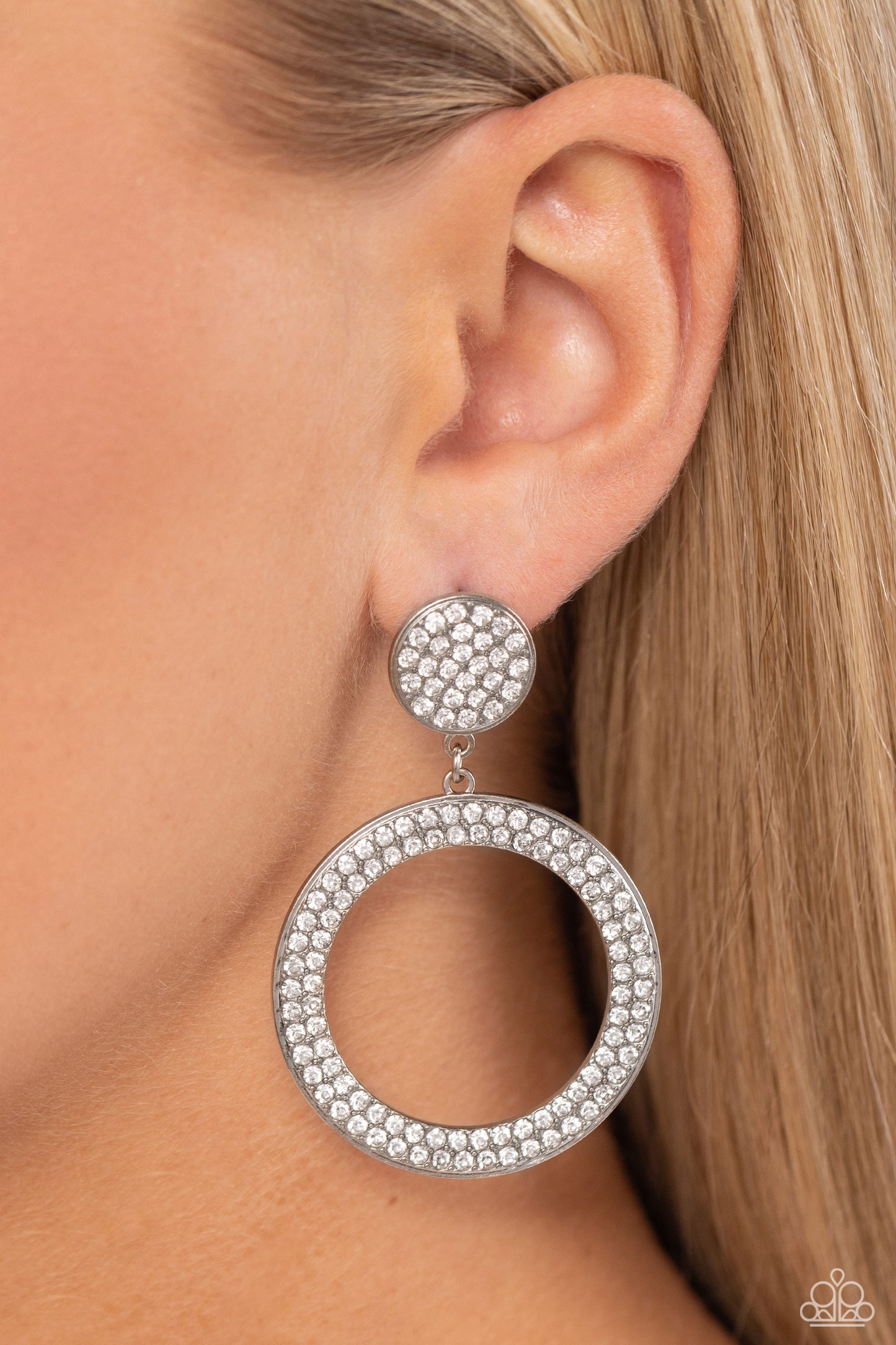 Paparazzi Accessories GLOW You Away - White Encrusted in rows of glassy white rhinestones, a flat silver hoop swings from the bottom of a white rhinestone dotted silver frame for a statement-making finish. Earring attaches to a standard post fitting. Sold