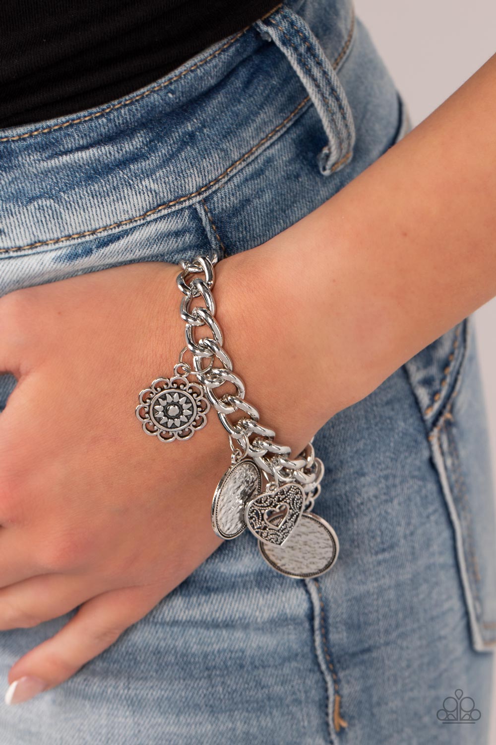 Paparazzi Accessories Complete CHARM-ony - Silver A whimsical collection of silver charms — including an airy heart, flowers, and textured coin-like discs — dance from a chunky silver chain around the wrist, creating a boisterous fringe. Features an adjus