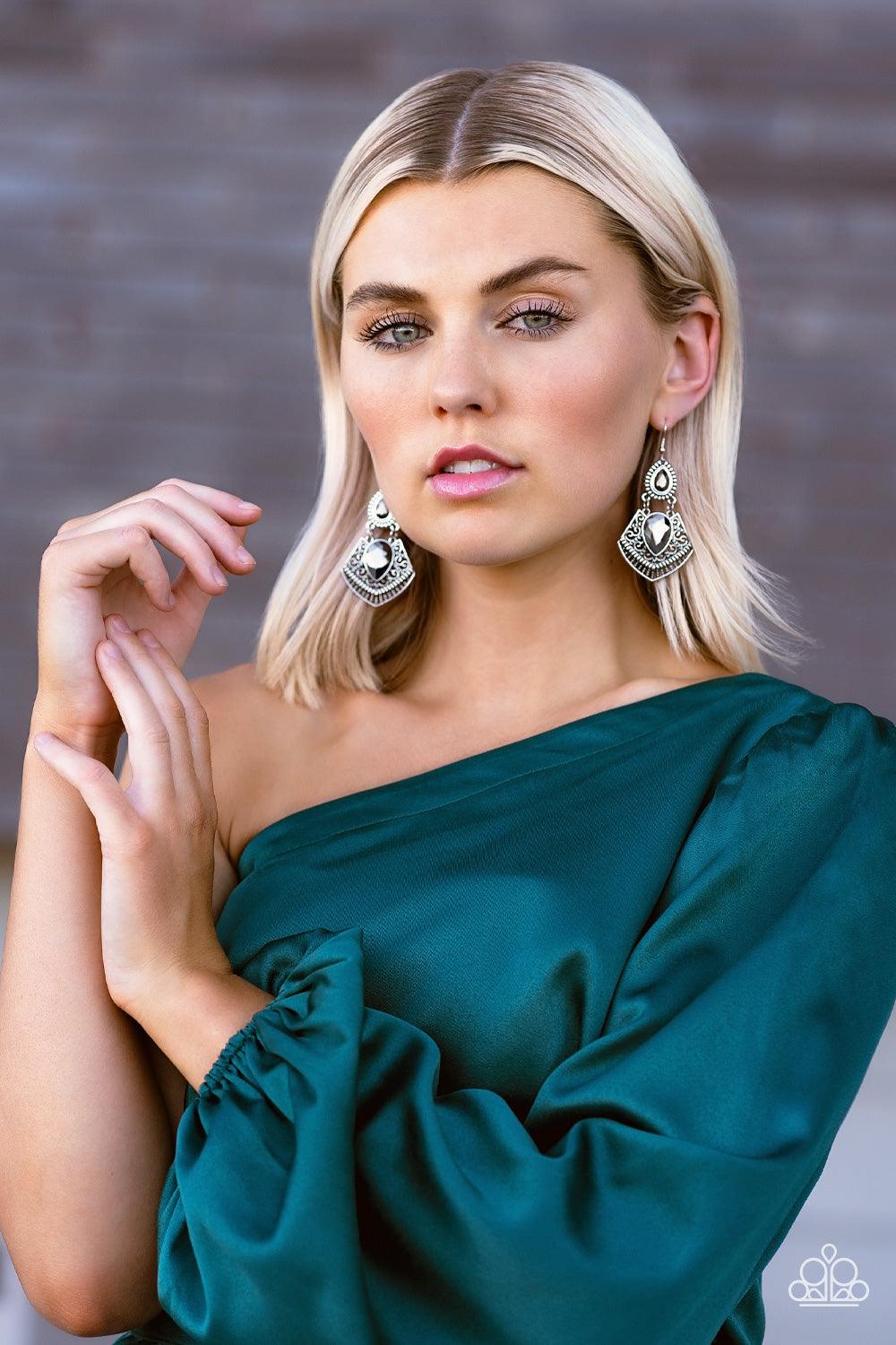 Paparazzi Accessories Royal Remix - Silver A hematite teardrop gem is pressed into a flared silver frame swirled in intricate patterns. The flared frame swings below a smaller hematite teardrop that is wrapped in a border of silver studs, creating a swing