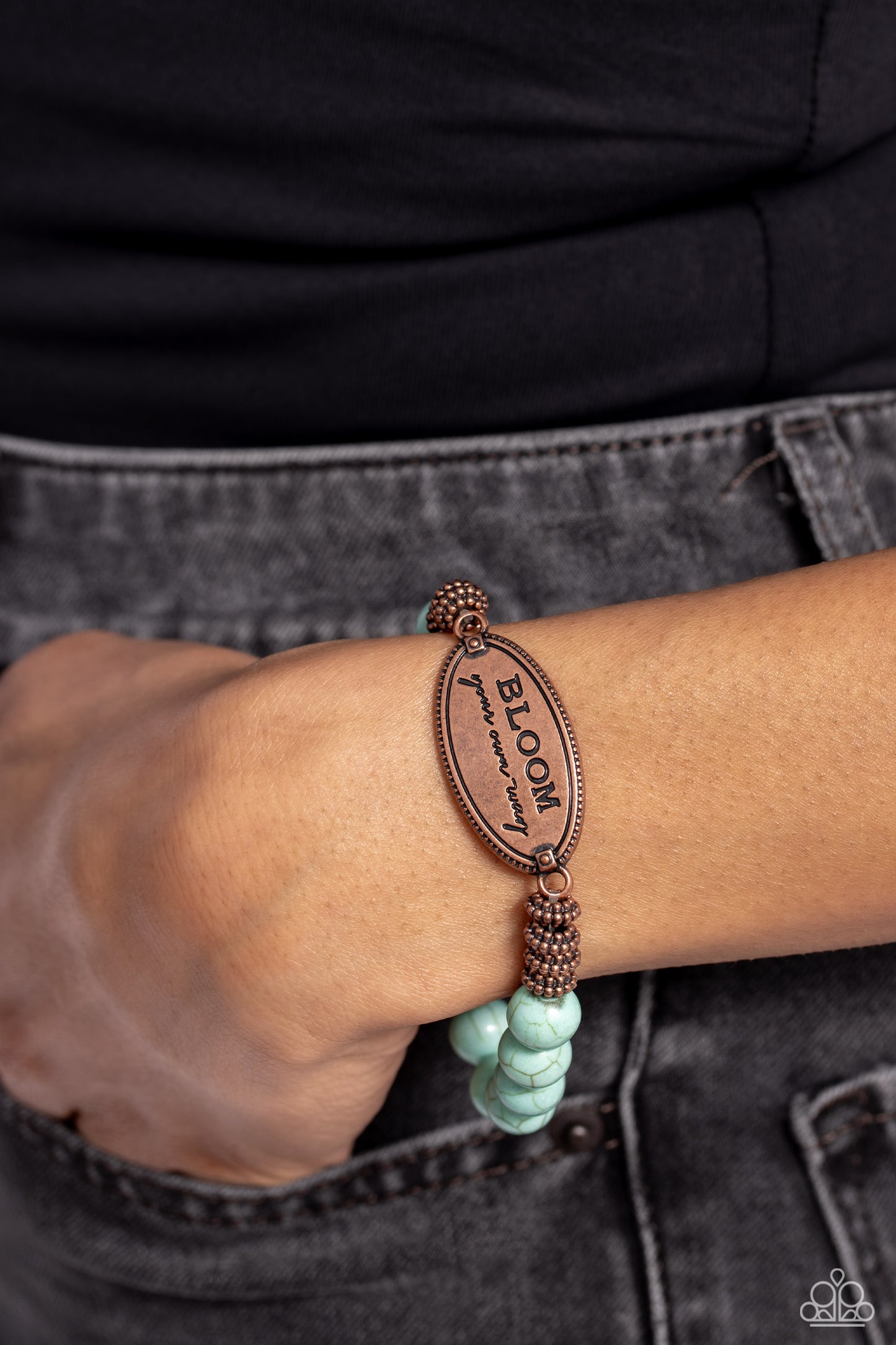Paparazzi Accessories Bedouin Bloom - Copper An asymmetrical, textured, copper oval pendant features the phrase "BLOOM your own way" in a variety of fonts to emphasize the inspirational message. Four textured brass wheels fan out from the pendant to a ref