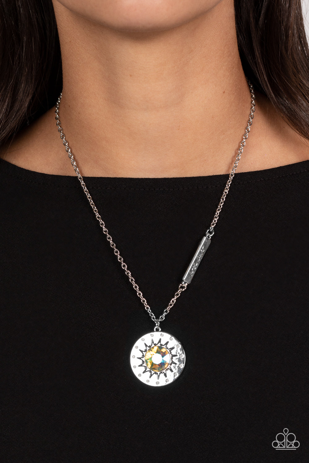 Paparazzi Accessories Sundial Dance - Multi Hanging from the bottom of a classic silver chain, a silver pendant, with a lightly hammered sheen rests. Stamped on the pendant, a sun outlines the center with dainty opalescent rhinestones outlining the shape.