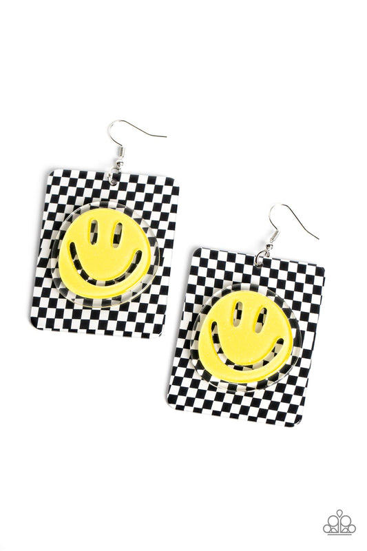 Paparazzi Accessories Cheeky Checkerboard - Yellow Set against a trendy, checkerboard backdrop, an oversized, sparkly, yellow smiley face stands out for a cheerfully captivating statement piece near the ear. Earring attaches to a standard fishhook fitting
