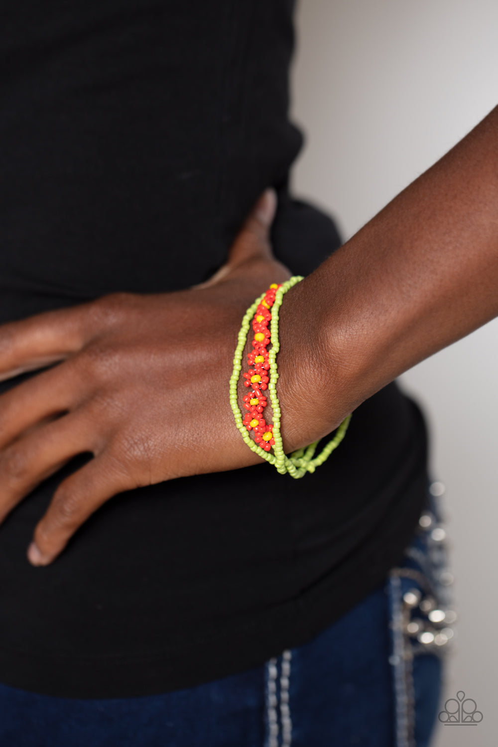 Paparazzi Accessories Buzzworthy Botanicals - Red Strung along the entirety of three elastic stretchy bands, apple green seed beads coalesce around the wrist. Featured on one of the bands of green seed beads, blooming red seed bead flowers, with yellow se