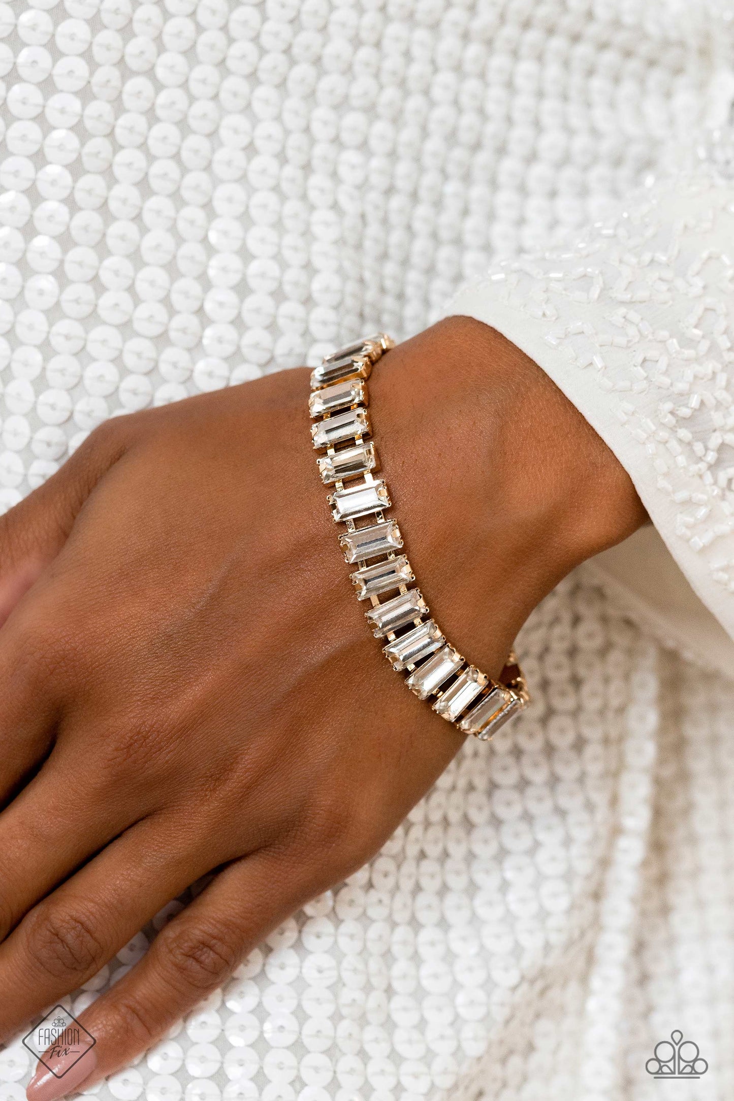 Paparazzi Accessories Darling Debutante - Gold Set in prominent, pronged gold fittings, a glassy collection of emerald-cut, white gems fall in line around the wrist, creating a stunning, light-catching display. Features an adjustable clasp closure. Sold a