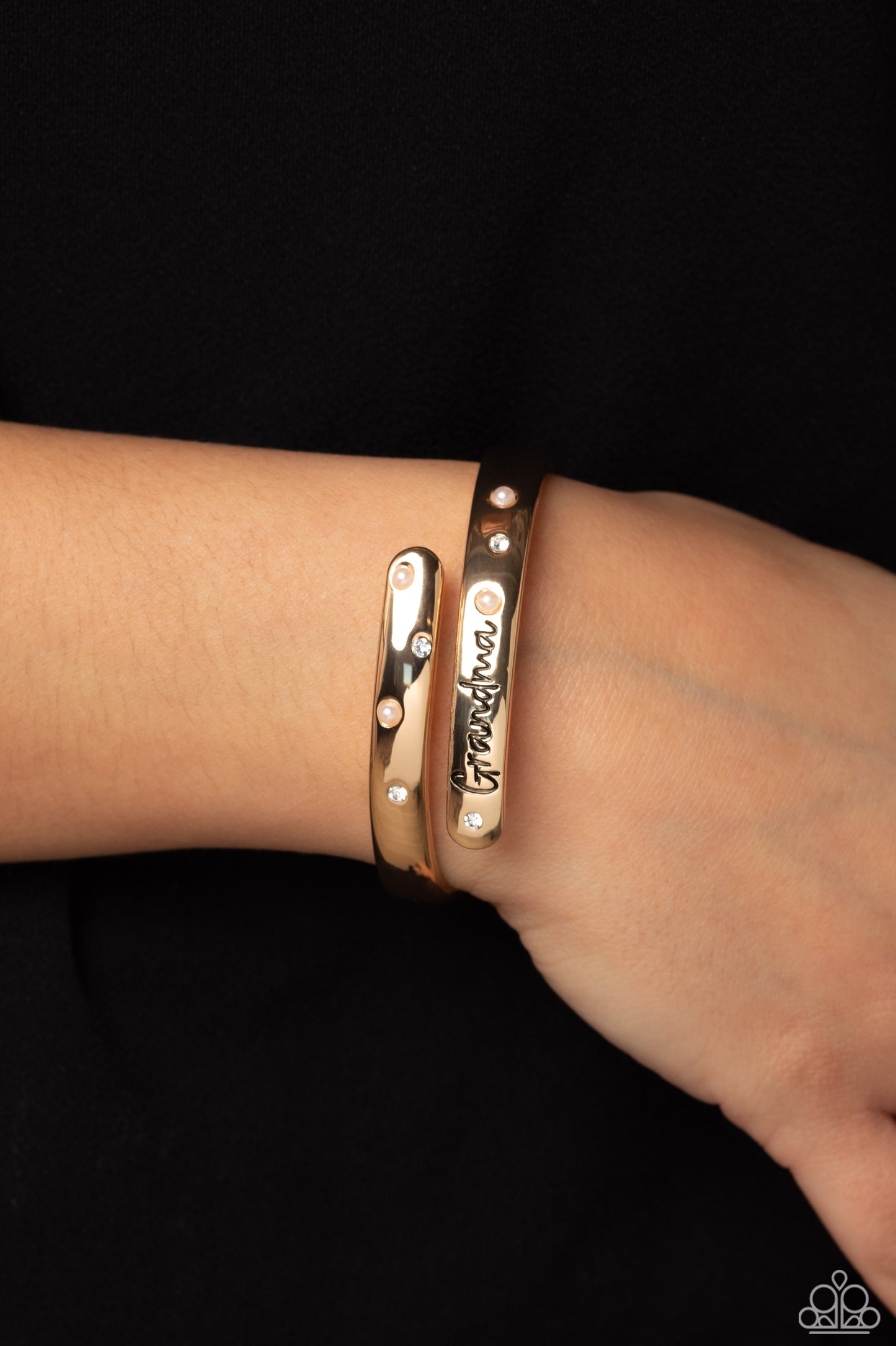 Paparazzi Accessories Gorgeous Grandma - Gold High-sheen gold curves into a hinged closure around the wrist. Featured on the upper curve, dainty pearls and white rhinestones alternate in a zig-zag pattern for a refined shimmer. The lower curve of gold fea