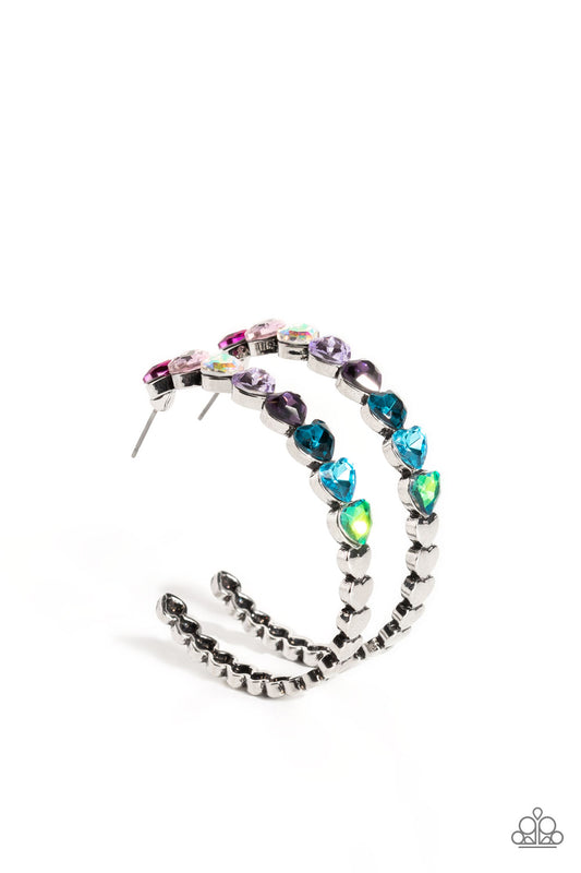 Paparazzi Accessories Hypnotic Heart Attack - Multi Featuring a scalloped heart frame, glittery heart rhinestones in shades of pink, iridescence, purple, blue, and a refracted green shimmer slowly decrease in size as they curve down the ear to meet dainty