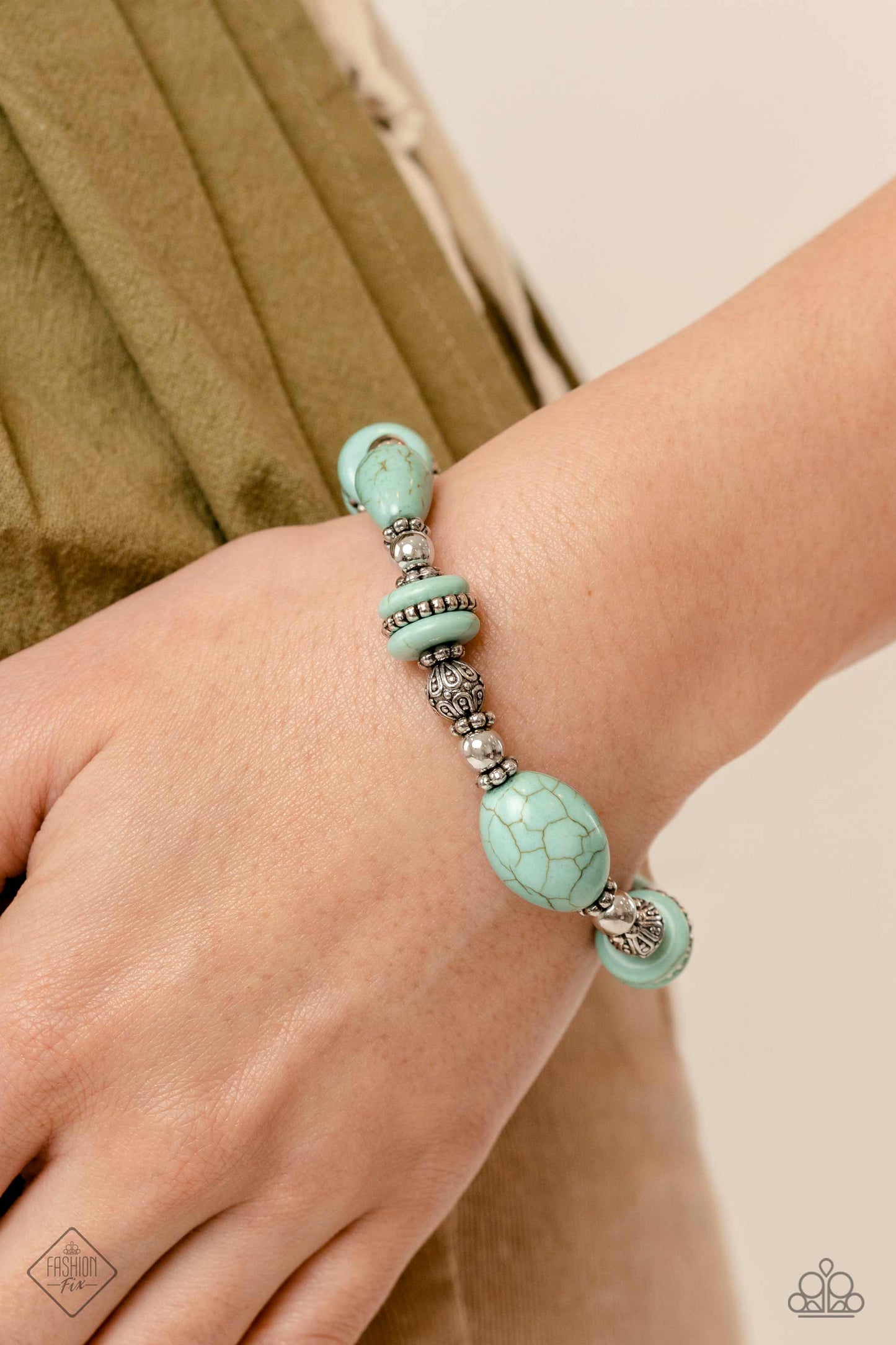 Paparazzi Accessories Changing Cleopatra - Blue Infused along an elastic stretchy band, an Egyptian-esque collection of muted turquoise stones in various sizes, striped silver beads, textured silver beads, floral silver wheel beads, and silver accents wra