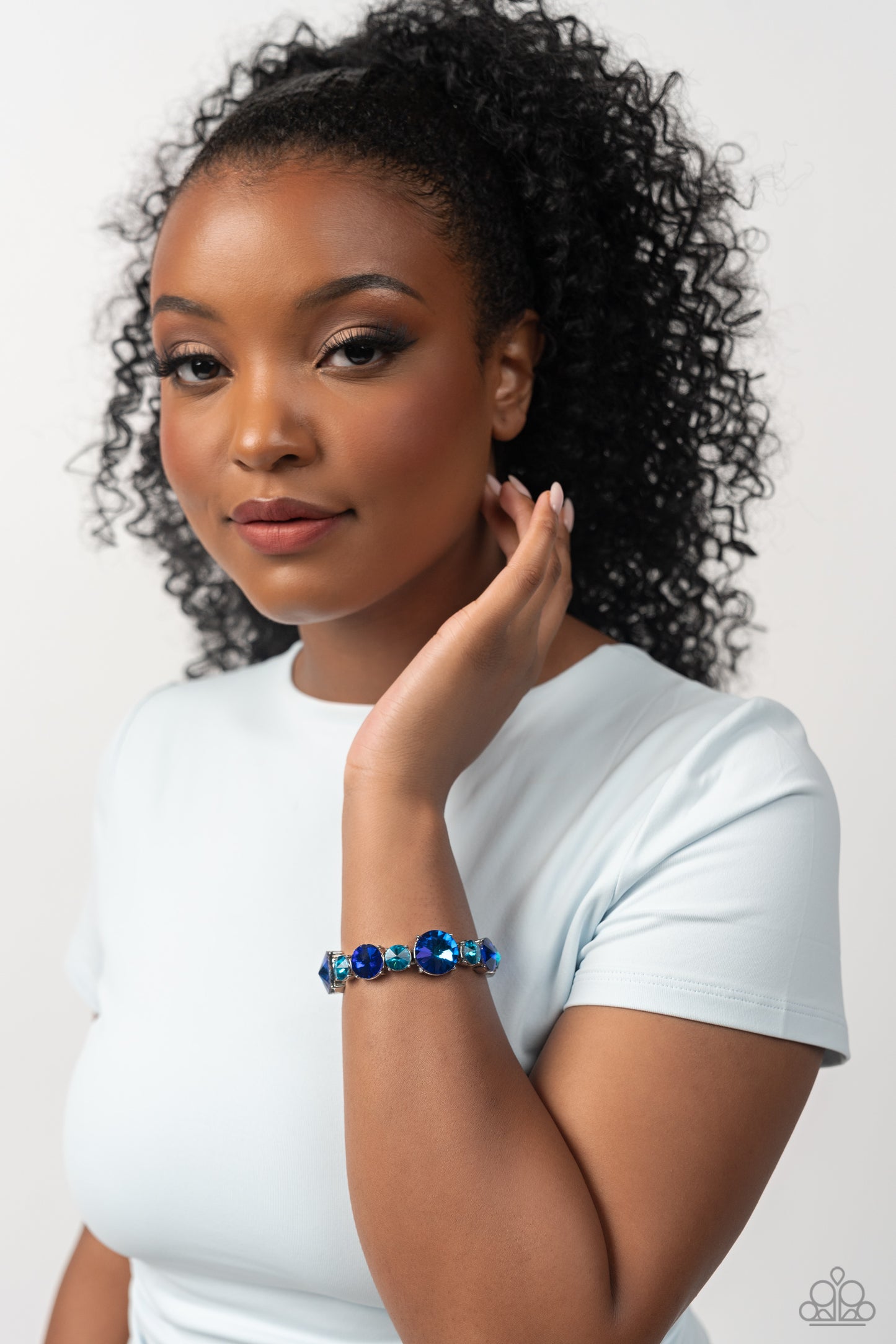 Paparazzi Accessories Refreshing Radiance - Blue Pressed in silver-pronged frames, vibrant blue gems in varying sizes and shades alternate along stretchy bands around the wrist, creating a colorful pop of color. The larger blue gems feature a stellar UV s