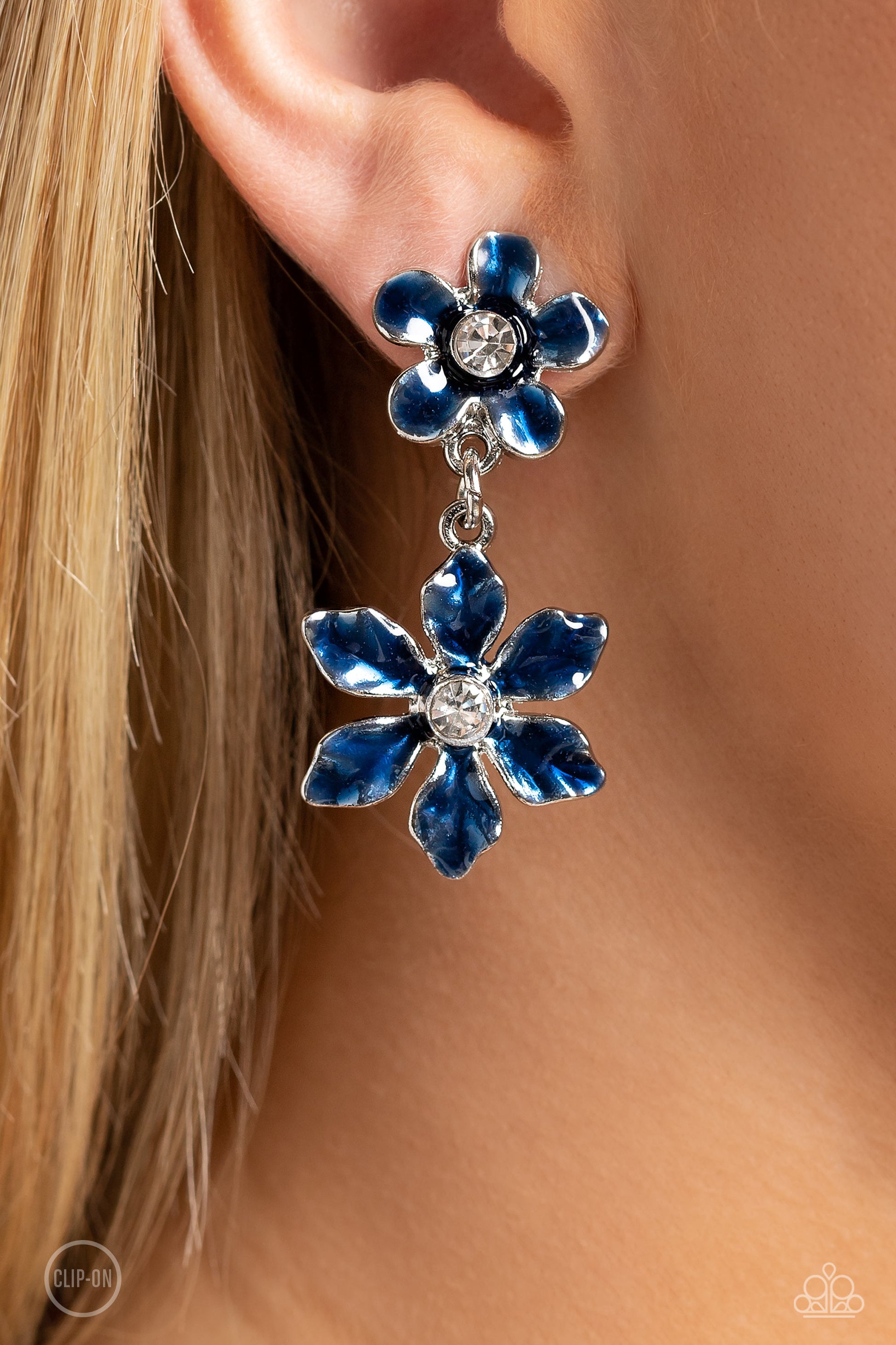 Paparazzi Accessories Transparent Talent - Blue *Clip-On A navy transparent flower with pinched petals blooms around a glittery white gem center. The large flower swings from a second transparent navy flower, featuring a smaller size with fanned-out petal