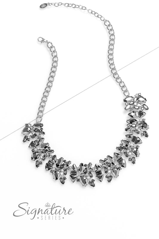 Paparazzi Accessories The J.J. Smoldering clusters of gleaming hematite and smoky sparkle erupt into an edgy exhibition along the collar. Each cluster is shaped by teardrop- and marquise-cut gems, exaggerated by pronged fittings as they collide with class