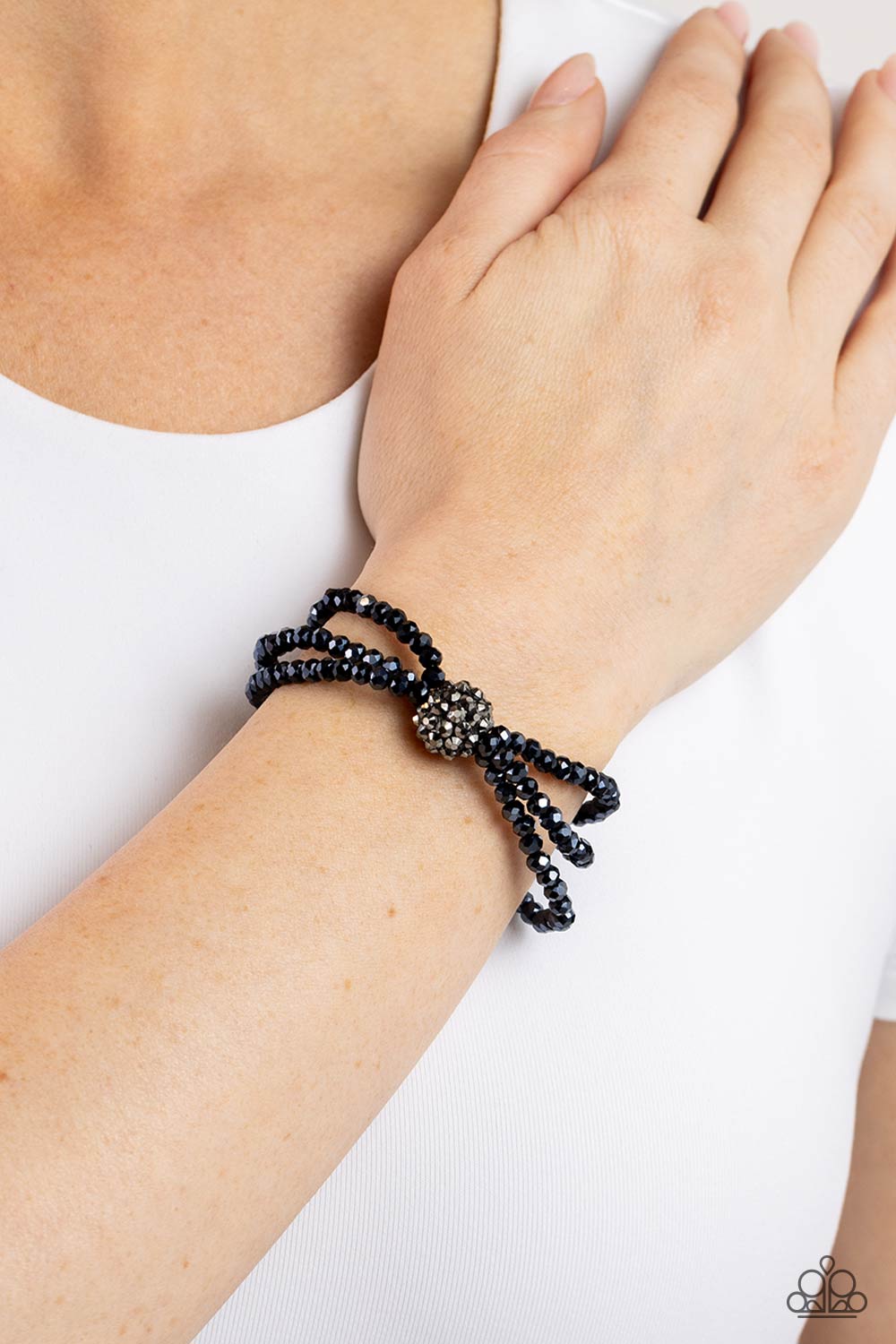 Paparazzi Accessories Twisted Theme - Blue Featuring faceted finishes, blue beads are threaded along three stretchy bands around the wrist. Encrusted in gunmetal spiky-like details, an oversized ball twists at the center of the wrist for a fierce industri