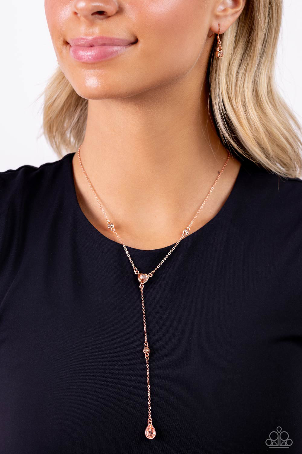 Paparazzi Accessories Lavish Lariat - Copper Dainty strands of glistening shiny copper chain delicately knot into a timeless tassel for a refined flair. Peachy gems in varying sizes and in round, teardrop, and heart applications are infused along the shin