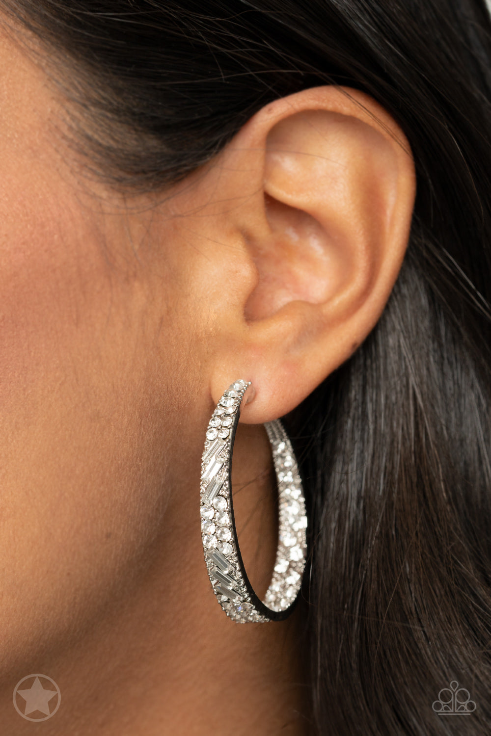 Paparazzi Accessories GLITZY By Association - White The front facing surface of a chunky silver hoop is dipped in brilliantly sparkling rhinestones while light-catching texture wraps around the back. The interior of the hoop features the opposite pattern,