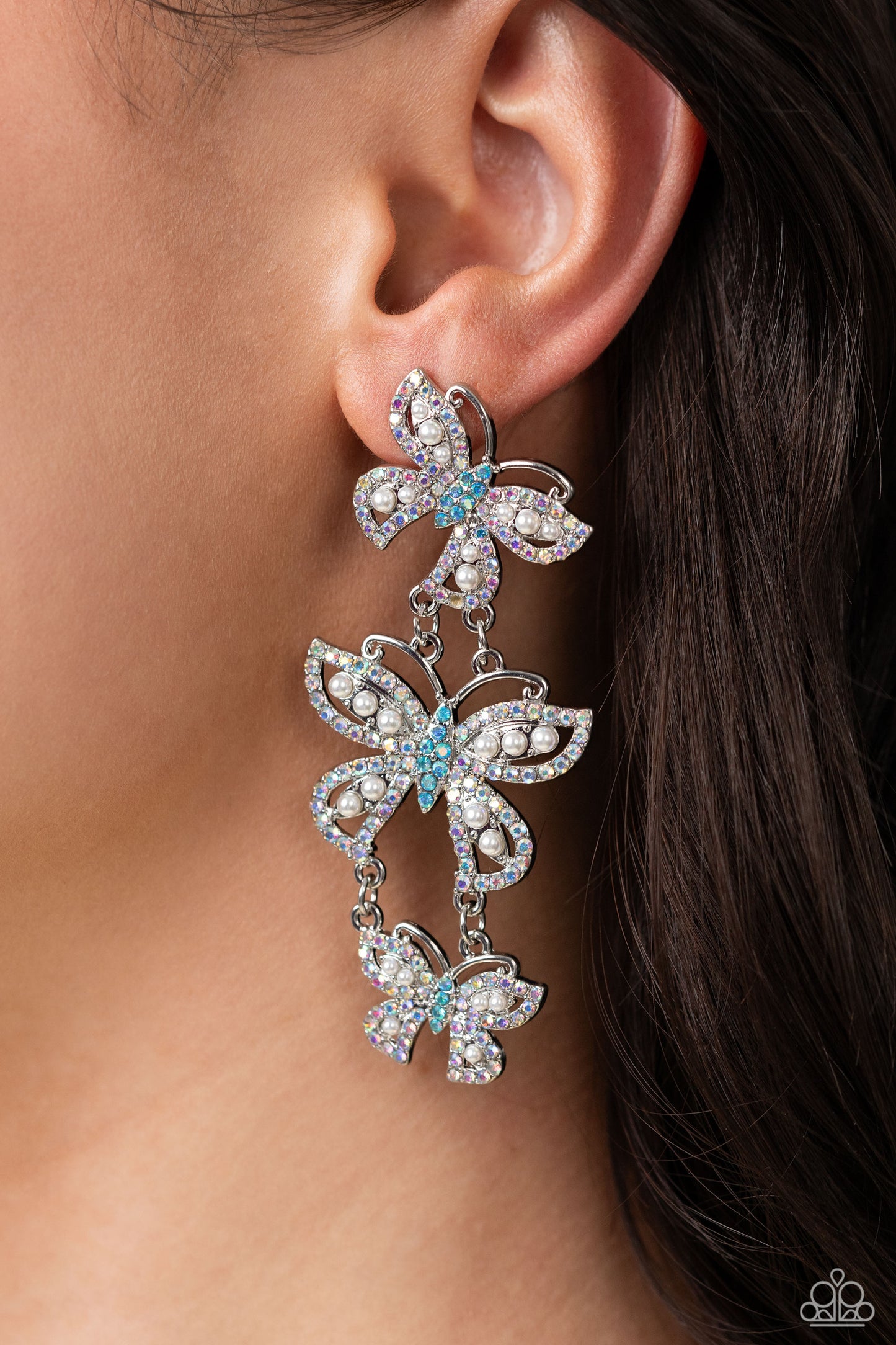 Paparazzi Accessories Fluttering Finale - Multi An airy trio of silver butterflies of various sizes link into a whimsical lure. Each butterfly's wings have been dipped in iridescent rhinestones and white pearls, while the bodies are dipped in blue iridesc