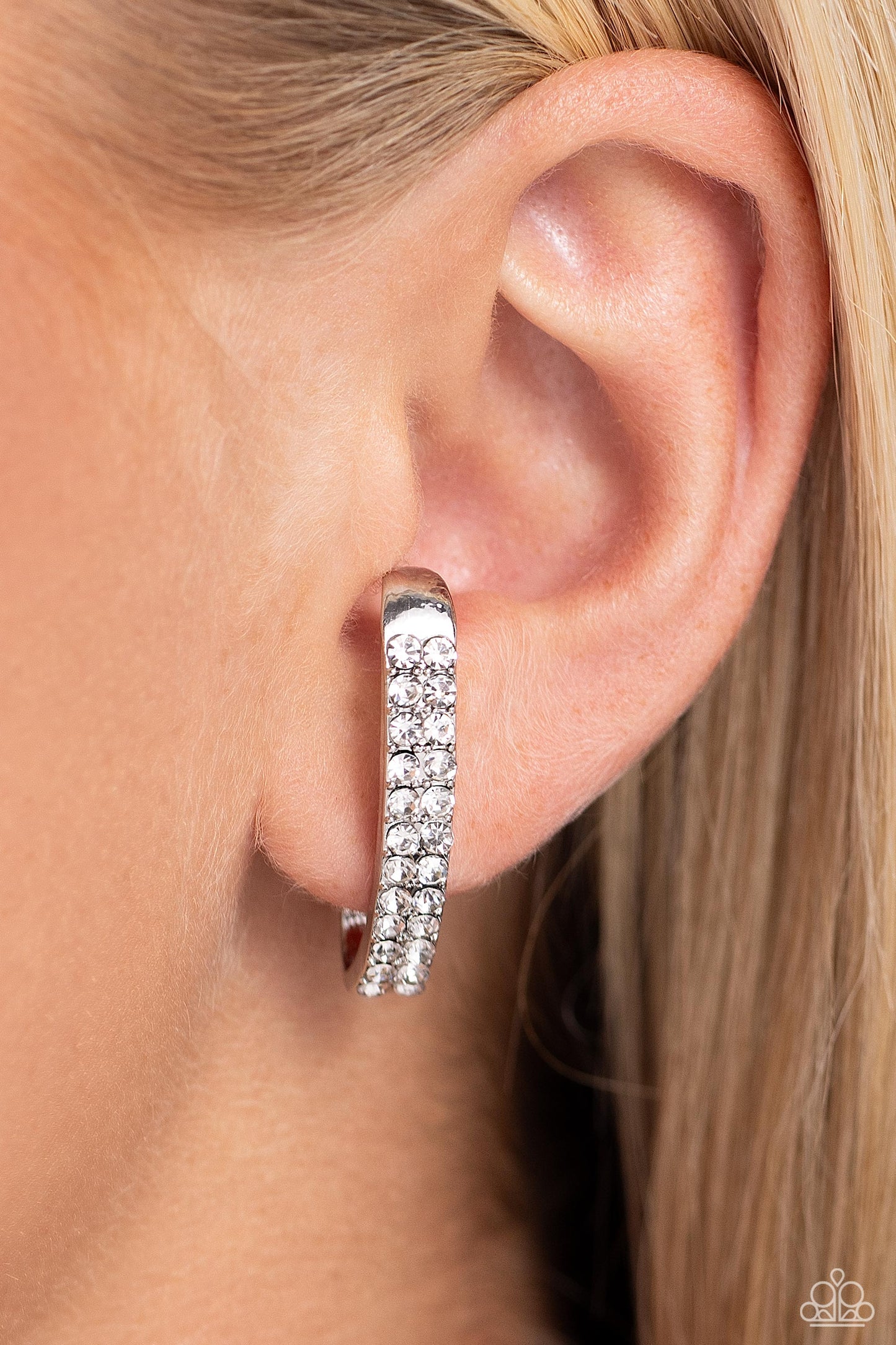 Paparazzi Accessories Sliding Series - White Two rows of glassy white rhinestones are set along the center of a curved silver bar for a refined display of dazzle. Features a sleek surface for sliding ability to desired position on the ear. Due to its stru