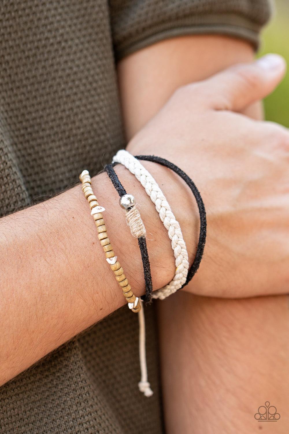 Paparazzi Accessories Sahara Pilgrim - Black Featuring silver, stone, and wooden beaded accents, a mismatched collection of suede and twine-like braided bands layer across the wrist for an earthy look. Features an adjustable sliding knot closure. Sold as