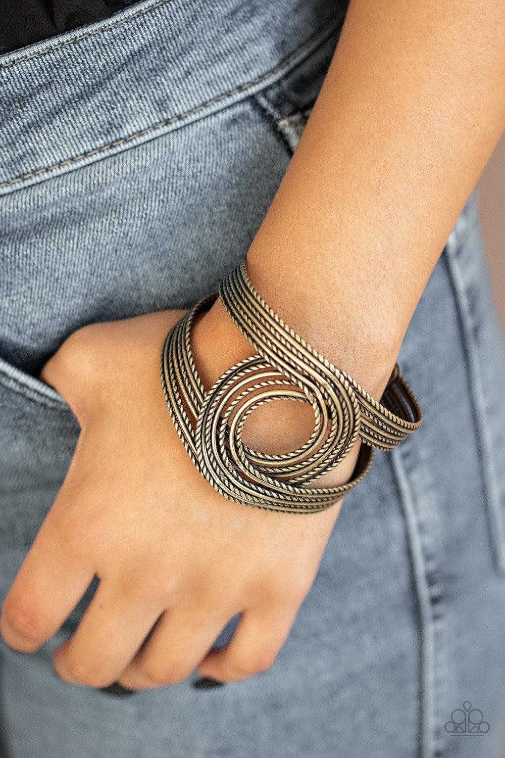 Paparazzi Accessories Rustic Coils - Brass Brushed in an antiqued finish smooth and twisted rope-like brass wires loop and curl around the wrist, creating a rustic cuff. Jewelry