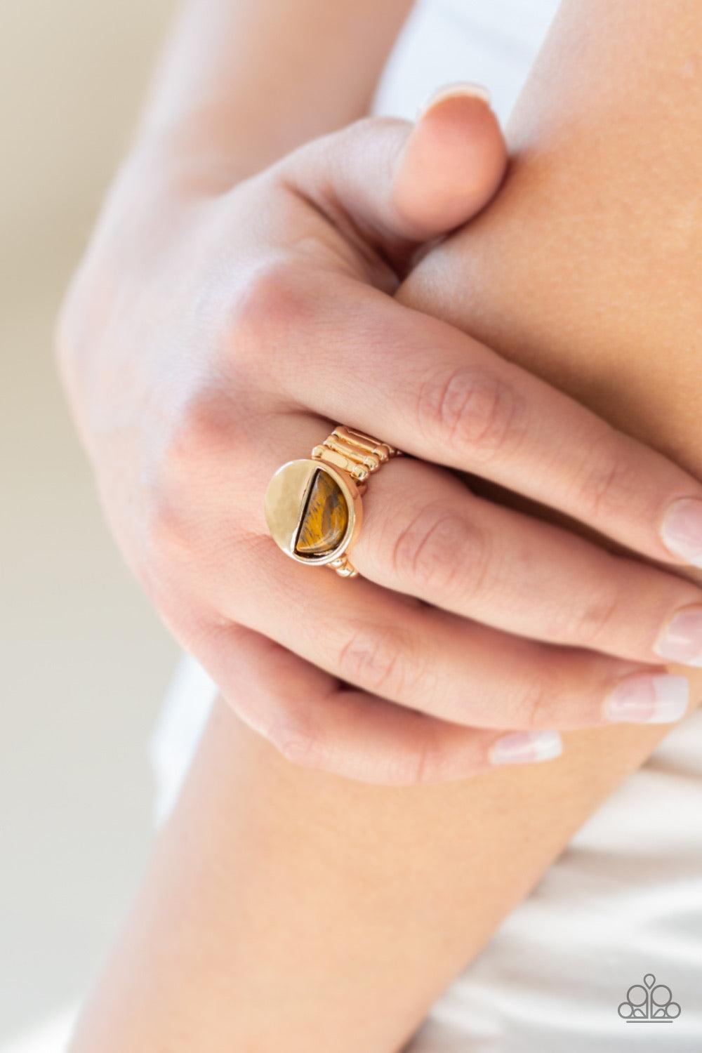 Paparazzi Accessories Stone Seeker - Brown Chiseled into a tranquil crescent shape, a radiant Tiger's Eye stone is pressed into the bottom half of a circular gold frame for an on-trend look. Features a stretchy band for a flexible fit. Jewelry