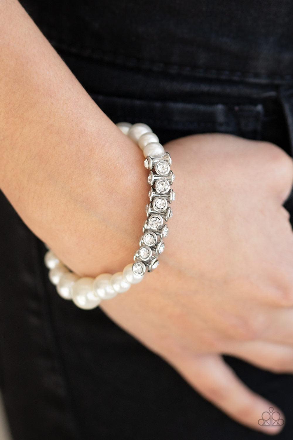 Paparazzi Accessories Traffic-Stopping Sparkle - White A collection of white pearls and white rhinestone dotted silver frames are threaded along stretchy bands around the wrist, creating a sparkling centerpiece. Sold as one individual bracelet. Jewelry