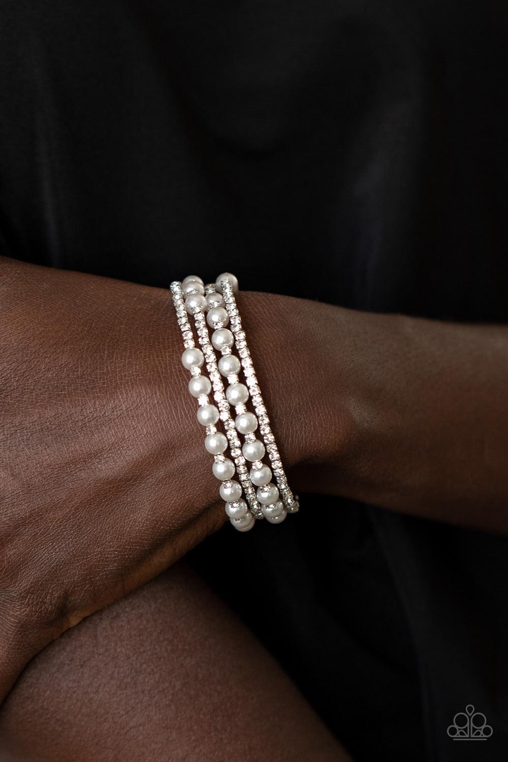 Paparazzi Accessories Starry Strut - White Row after row of glassy white rhinestones and classic white pearls coil around the wrist, creating a blinding infinity wrap bracelet. Sold as one individual bracelet. Jewelry