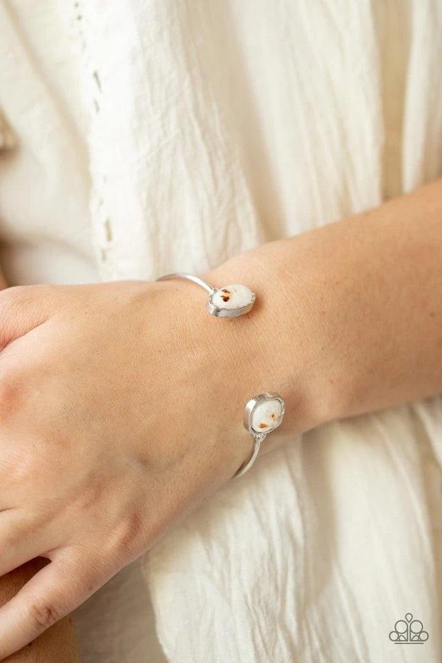 Paparazzi Accessories Don’t BEAD Jealous - White Flecks of iridescent shell-like pieces are encased inside two mismatched glassy white beads at both ends of a dainty silver open-faced cuff. The shimmery beads are encased in imperfectly hammered silver fra