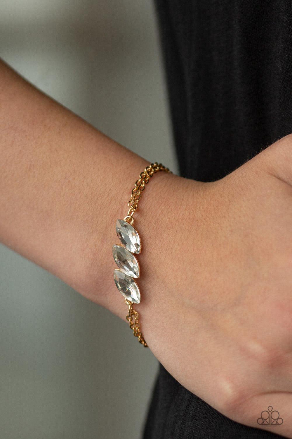Paparazzi Accessories Pretty Priceless - Gold Featuring regal marquise-cuts, a trio of glittery white rhinestones join across the center of the wrist for a timeless look. Features an adjustable clasp closure. Sold as one individual bracelet. Jewelry