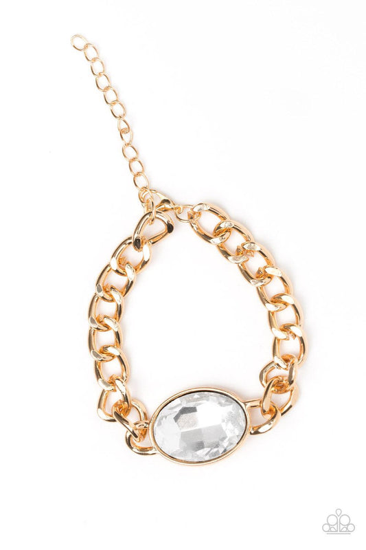 Paparazzi Accessories Luxury Lush - Gold An oversized white gem attaches to a bold gold chain, creating a dramatic centerpiece atop the wrist. Features an adjustable clasp closure. Jewelry