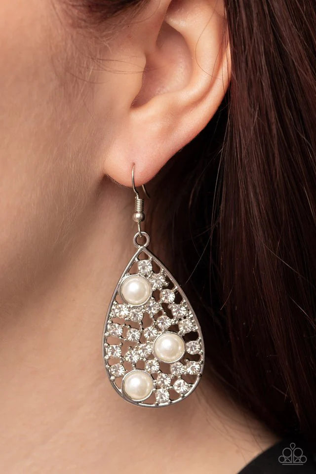 Paparazzi Accessories Bauble Burst - White Encased in pronged silver fittings, a glitzy collection of glassy white rhinestones join pearly white beads inside of a shiny silver teardrop for a glamorous finish. Earring attaches to a standard fishhook fittin