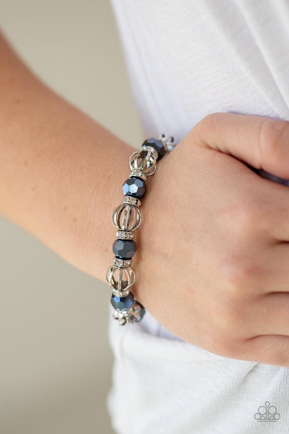 Paparazzi Accessories Metro Squad - Blue A collection of airy silver beads, faceted blue metallic beads, and white rhinestone encrusted rings are threaded along a stretchy band around the wrist for a glamorous look. Jewelry