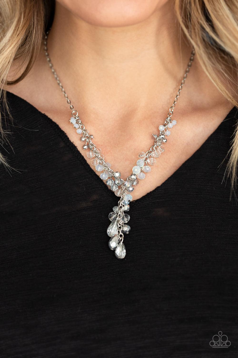 Paparazzi Accessories Iridescent Illumination - Silver A fringe of white, opaque, and metallic flecked crystal-like beads dangle from the bottom of a shimmery silver chain. Matching round and teardrop beads cascade from an extended silver chain at the cen