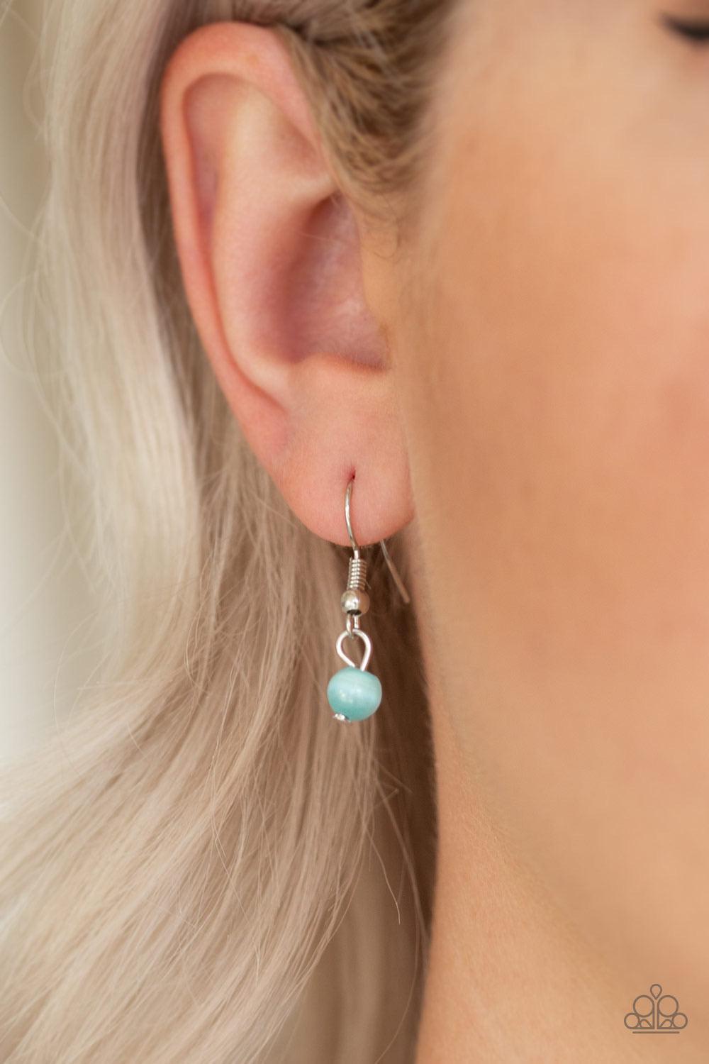Paparazzi Accessories One Heart - Blue Featuring a glowing blue moonstone center, an oversized heart frame radiating with silver filigree and glittery white rhinestones swings from the bottom of a lengthened silver chain for a whimsical look. Features an