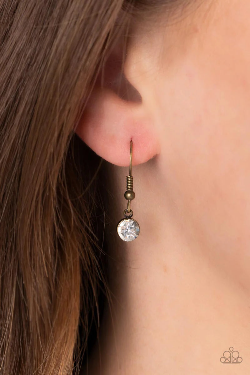 Paparazzi Accessories Surrealist Sparkle - Brass A warped brass frame gently folds around an oversized white teardrop gem center, resulting in a gritty yet glamorous pendant at the bottom of a lengthened brass chain. Features an adjustable clasp closure.