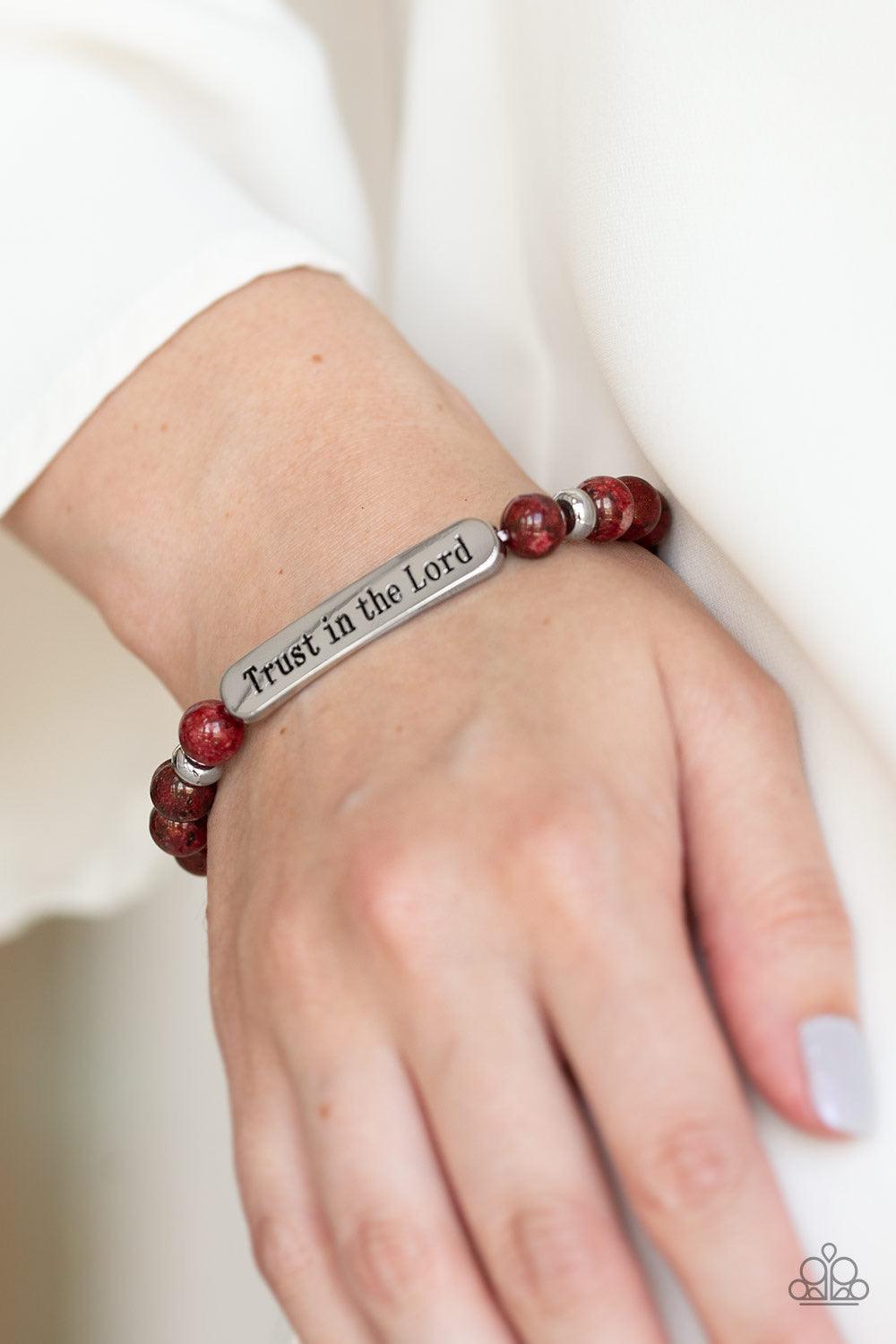 Paparazzi Accessories Trust Always ~Red Infused with dainty silver accents, a collection of glassy red stone beads and a shimmery silver frame stamped in the phrase, "Trust in the Lord", are threaded along a stretchy band around the wrist for an inspirati