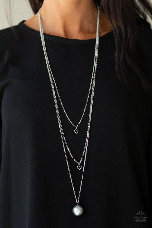 Paparazzi Accessories Hearty Heirloom - Silver Three shimmery silver chains cascade down the chest. Two dainty silver heart charms swing from the uppermost chains, giving way to a dramatically oversized silver pearl for a romantic finish. Features an adju