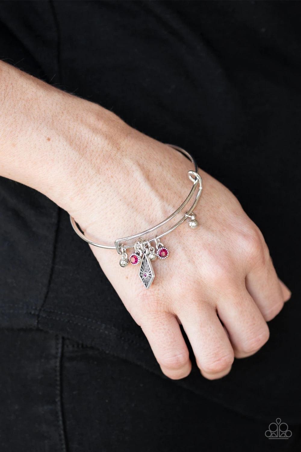 Paparazzi Accessories Treasure Charms - Pink A collection of shimmery silver beads and glittery pink rhinestone accents slide along a sleek bar fitting, creating whimsical charms as they glide along the dainty silver bangle. Sold as one individual bracele