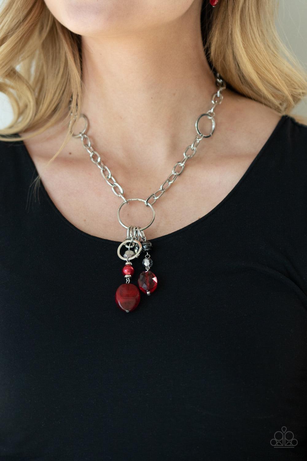 Paparazzi Accessories Lay Down Your CHARMS - Red A glittery compilation of faceted, smooth, and pearly red, black, and silver beaded charms swing from the bottom of a silver ring that attaches to a chunky silver chain below the collar for a colorfully cha