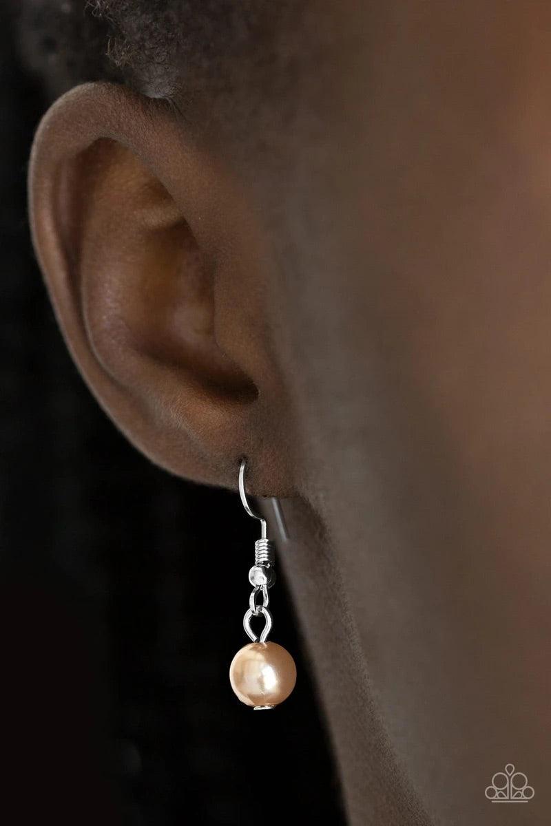 Paparazzi Accessories Put on Your Party Dress - Brown Pinched between white rhinestone encrusted frames, strands of classic brown pearls layer below the collar for a timeless look. Features an adjustable clasp closure. Sold as one individual necklace. Inc