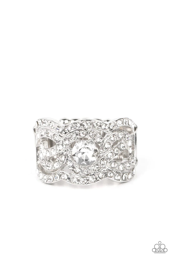 Paparazzi Accessories Doting On Dazzle - White Wavy scalloped rows encased with rhinestones are topped by a central, sparkling rhinestone to provide an elegant and timeless look. Features a stretchy band for a flexible fit. Sold as one individual ring. Je