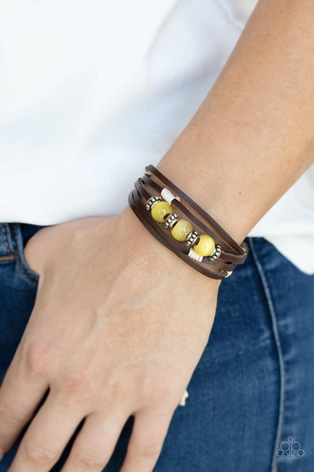Paparazzi Accessories Homespun Radiance - Yellow Infused with studded silver accents, a row of Illuminating cat's eye stone beads adorn the centermost strand of layered leather bands around the wrist for a colorful seasonal look. Features an adjustable sl