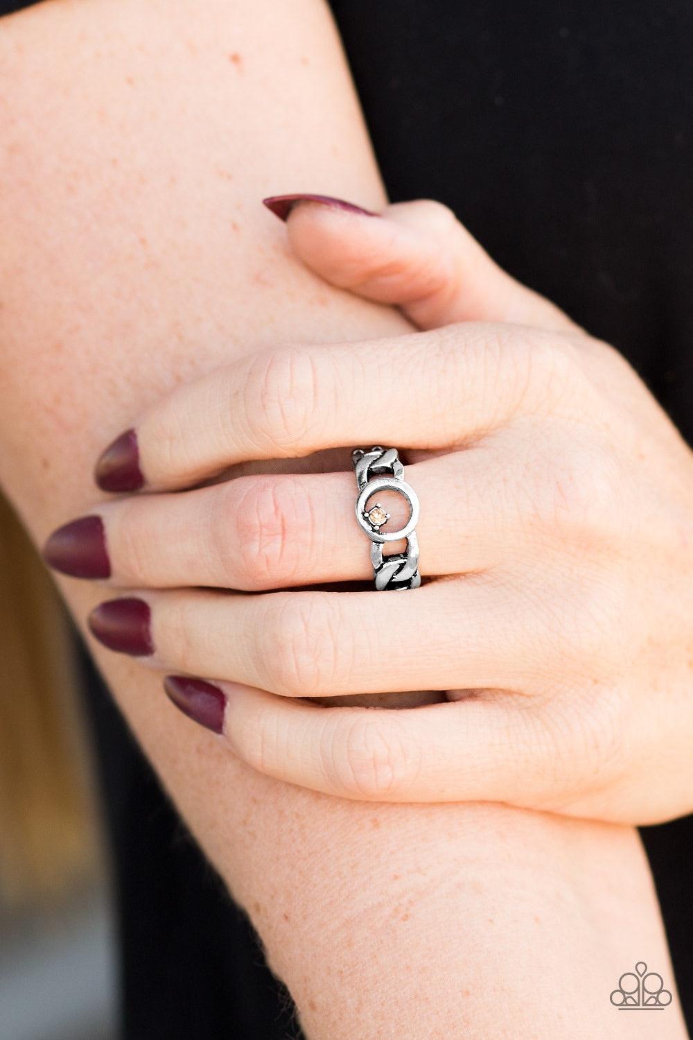 Paparazzi Accessories Rogue Sparkle - Brown Antiqued silver links join across the finger, creating an edgy band. A dainty topaz rhinestone asymmetrically dots the center link for a sassy finish. Features a dainty stretchy band for a flexible fit. Jewelry