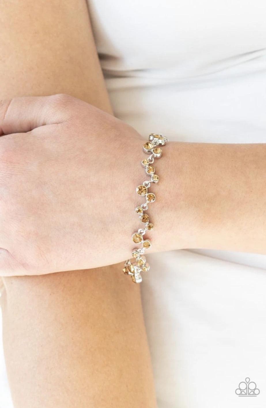 Paparazzi Accessories Starlit Stunner - Brown Varying in size, a collection of golden topaz rhinestones connect across the wrist for a timeless look. Features an adjustable clasp closure. Jewelry