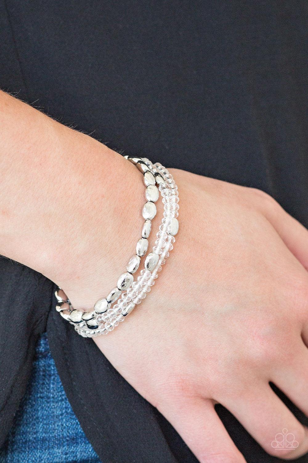 Paparazzi Accessories Hello Beautiful - White Infused with hints of silver, dainty white crystal-like beads are threaded along stretchy bands, creating whimsical layers across the wrist. Sold as one set of three bracelets. Jewelry