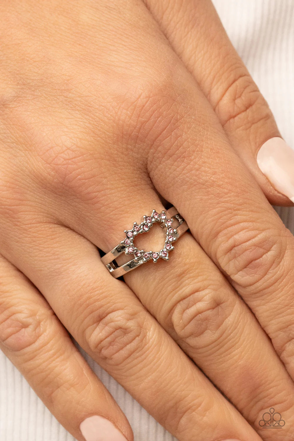 Paparazzi Accessories First Kisses - Pink Pink rhinestone pronged silver fittings coalesce into an airy heart frame atop the center of layered silver frames, resulting in a romantic centerpiece atop the finger. Features a dainty stretchy band for a flexib