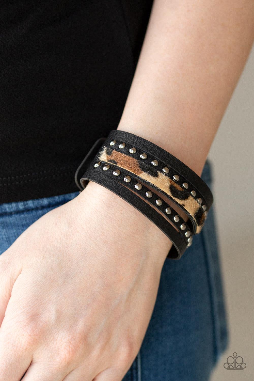 Paparazzi Accessories Born to be WILDCAT - Brown A thick band of black leather has been spliced into layered bands that have been studded and printed in a fuzzy cheetah print for a wild look. Features an adjustable snap closure. Jewelry