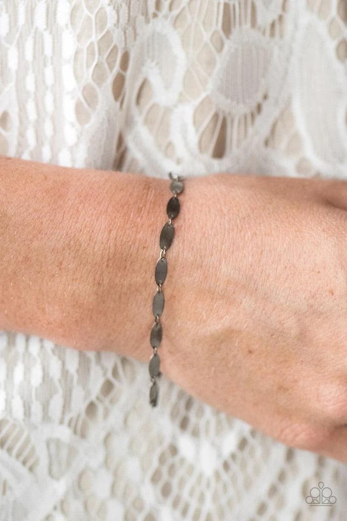 Paparazzi Accessories Flash Fire - Black Flat gunmetal frames link together around the wrist, creating a dainty chain. Brushed in a high-sheen finish, the flat gunmetal surfaces easily reflect the light creating a flashy palette from any angle. Features a
