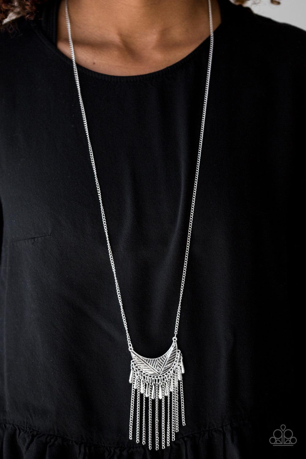 Paparazzi Accessories Happy is the Huntress - Silver Radiating in linear textures, a glistening silver crescent swings from the bottom of a lengthened silver chain. Shimmery silver chains and flared silver beading swings from the bottom of the tribal insp